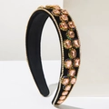 Detailed macro view of plush black velvet headband with champagne pink crystals - Champagne