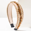 Knitted headband with amber rhinestones and brown stitching on white geometric background - Brown