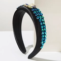 Detail of padded black satin headband with blue rhinestones and gold insect accessory - Black