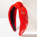 Détail d'un serre-tête noué rouge orné de strass brillants sur un support géométrique - Rouge - Strass LOVE