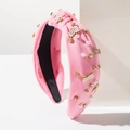 Dettaglio del cerchietto imbottito rosa con perle, strass e ciondoli LOVE in metallo dorato - Rosa LOVE