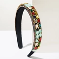 Detail view of baroque velvet headband with colorful rhinestones on a white stand - Colorful