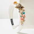 Dettaglio del cerchietto barocco con farfalla dorata, fiori e strass su raso bianco - Bianco