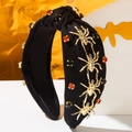Detail of Halloween headband with gold metal spiders and sparkling red gemstones - Black
