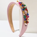 Pink satin padded headband decorated with colorful crystal rhinestones on a white stand - Pink