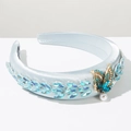 Detail of light blue satin headband with leaf-shaped gems and gold butterfly pearl charm - Blue