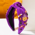 Purple Halloween knot headband with rhinestone pumpkin and bat charms on geometric background - Purple