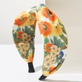 Detail of bohemian knotted headband with vibrant orange floral print on fabric texture - Yellow Mixed