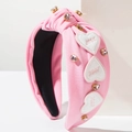 Détail d'un serre-tête rose en tissu avec écussons cœurs brodés et strass scintillants - Rose