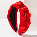 Detail of red fabric headband with sparkling heart patches and rhinestone accents - Red