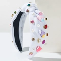 Close-up of knotted white headband with colorful rhinestones, pearls and heart charms - White