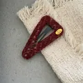 Detail of red and white knit triangular hair clip with golden handmade tag on a cozy texture - Triangle Knitted Snap Clip (300-B263) / Burgundy