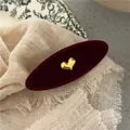 Detail of vintage red velvet oval hair clip with gold 3D heart and floral backdrop - Wine Red Heart
