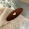 Detailed view of the dark brown fabric hair clip with a gold heart and sewing craftsmanship - Coffee Heart