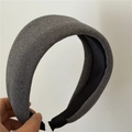 Gros plan d'un serre-tête épais en tissu gris avec texture laine et doublure satin - Gris