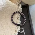 Detail of multi-color braided hair ties with metallic silk and resin buckle on tray - Pink Multi