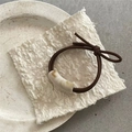 Detailaufnahme der Marmor-Muster Perle am minimalistischen Bogen Haargummi - Offwhite (Gebogene Perlenelastik)