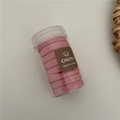 Detailed view of pink candy-colored towel hair ties stored in a clear cylindrical container - Pink