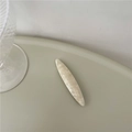 Dettaglio del fermaglio per capelli in acetato marmorizzato crema su sfondo minimal - Bianco Avorio (Foglia di Salice)