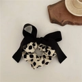 Elegant black hair scrunchie with a large bow featuring white polka dots on fabric - Black Polka Dot Bow Scrunchie