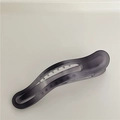 Makrodetail der durchscheinenden, mattgrauen Haarklammer mit ergonomisch geschwungenem Design - Dunkelgrau (Gebogen)