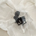 Dettaglio di tre mini mollette per capelli in plastica nera con molla in metallo - Nero opaco