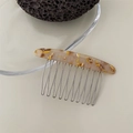 Close-up of elegant amber tortoiseshell pattern acrylic hair comb with 10 silver metal teeth - Khaki Color