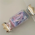 Detail of candy-shaped transparent box with colorful hair ties and gold metallic sealing - Blue Multicolor (Candy Box)