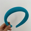 Detail of thick peacock blue sponge headband featuring a handmade woven label - Teal