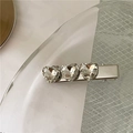Vue détaillée de la barrette en métal argenté ornée de trois cristaux étincelants en cœur - Blanc Style Court (Cœur Strass)