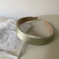 Diadema acolchada de satén verde salvia con diseño ancho sobre papel artístico blanco - Verde