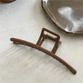 Dettaglio del fermaglio per capelli retrò con finitura in legno su base neutra - Forma a barra / Venature del legno scuro