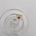 Mini haarclip bloem met amberkleurige harsblaadjes en een donkerpaarse strassteen - Transparante Bloem met Paarse Strass