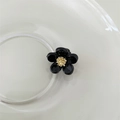 Mini haarclip in zwarte bloemvorm met een glanzende afwerking en gouden kern - Zwarte Bloem met Gouden Meeldraad