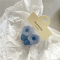 Set of two light blue floral hair clips with dark blue base on a display card - Blue