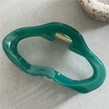 Détail de la pince à cheveux ondulée vert foncé avec ressort en métal doré brillant - Nuage Bleu Vert