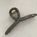 Macro shot of large translucent grey hair claw clip showing shiny texture and metal spring - Dark Gray
