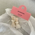 Pair of cream acetate bow hair clips with marble texture on pink display card - Iridescent White Bow