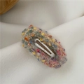 Close-up of donut-style colorful plush BB hair clip with textured knit fabric - Off White