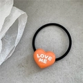 Elastic black hair tie with a bright orange heart pendant featuring LOVE ME text - Orange