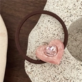 Detail shot of a pink acetate heart hair tie with a sparkling central crystal on a stone base - Pink Heart With Pink Rhinestone (J6.1)