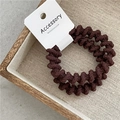 Dunkelbraunes spiralförmiges Haargummi-Set auf Accessoire-Karte in Erdtönen - Schraubverschluss / Dunkelbraun