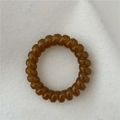 Elastic amber brown spiral telephone wire hair tie with a glossy jelly texture finish - Brown
