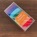 Dettaglio di un set di 48 elastici per capelli colorati in scatola su fondo legno - Rosso Multicolore