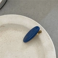Detailed view of a dark blue oval hair clip with gold France Handmade lettering on a plate - Navy Blue