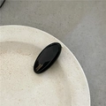 Detalle de una pinza para el pelo ovalada negra hecha a mano con letras doradas - Negro