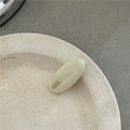 Close-up of handmade cream oval acetate hair clip with gold France lettering on ceramic dish - Off-white