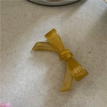 Gros plan d'une barrette à nœud en acétate ambre translucide avec texte de marque élégant - Jaune-vert