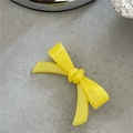 Gros plan détaillé d'une barrette à cheveux nœud en acétate jaune avec surface polie et nœud 3D - Jaune crème