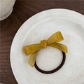 Détail d'un élastique nœud en résine ambrée avec gravure sur une assiette en céramique - Jaune-vert